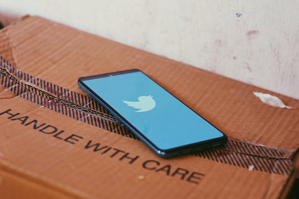 Foto eines Smartphones auf dessen Bildschirm das Twitter-Logo aufleuchtet. (Bild: Ravi Sharma/Unsplash)