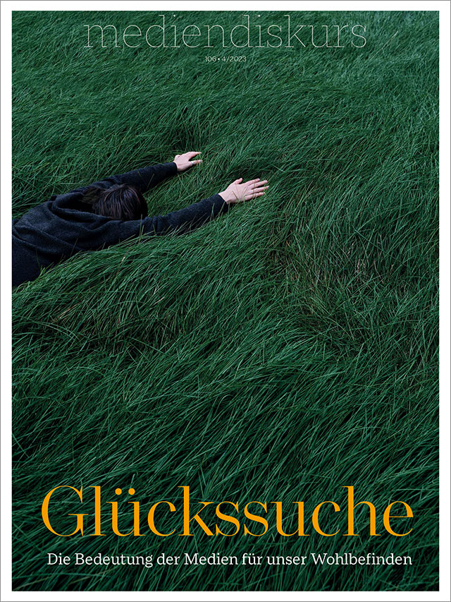 Person liegt im Gras. Cover mediendiskurs 106, 4/2023: Glückssuche. Die Bedeutung der Medien für unser Wohlbefinden. (Covermotiv © Sonia Dauer/unsplash)
